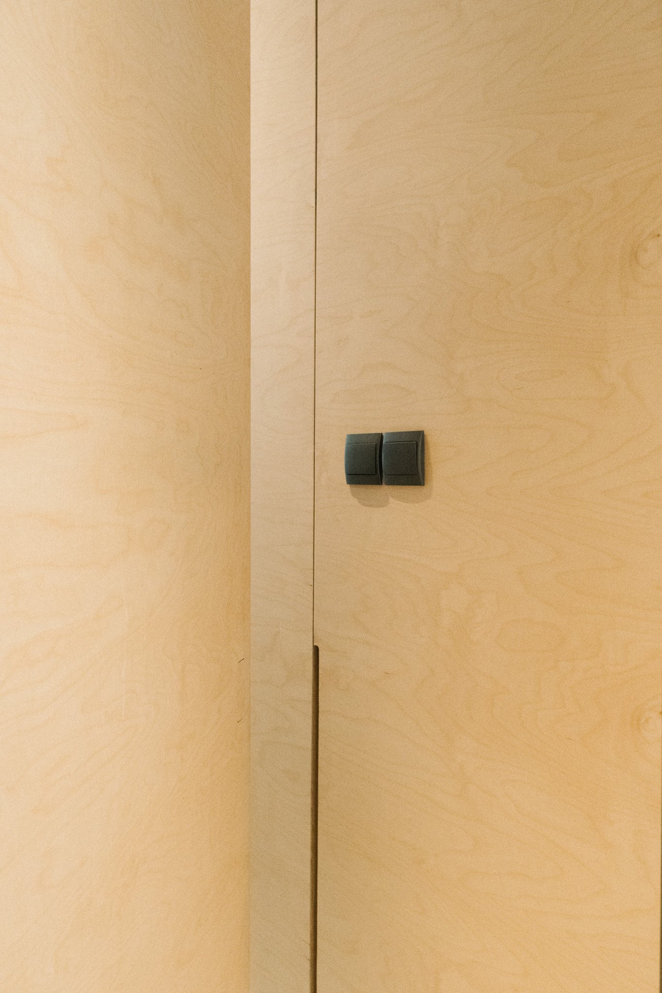 Birch plywood wardrobe doors with flush integrated pull handle and light switch, custom joinery by Roger&Sons
